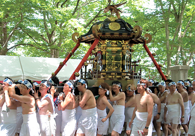 Locals carrying a mikoshi during a festival.